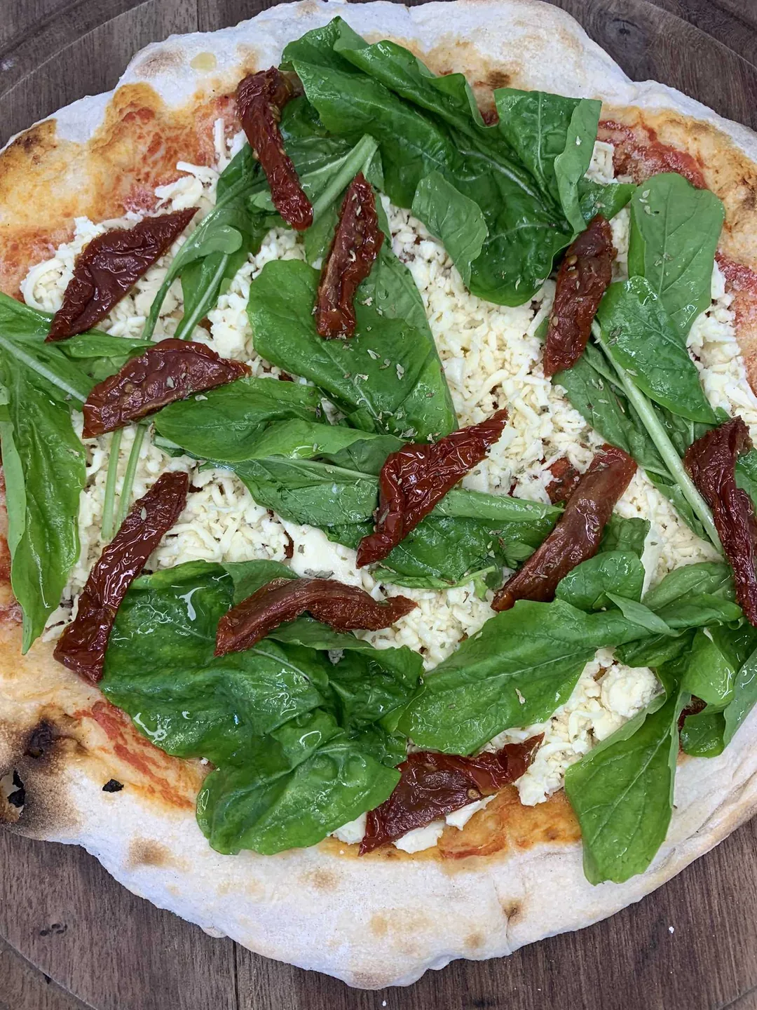 Pizza tomate seco e rúcula vegana
